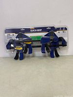 Front view of IRWIN Quick-Grip 4-pack clamps in original plastic packaging, showing size and clamping force details.