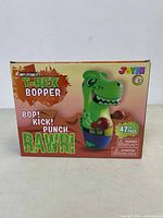 Front of the box showing the cartoon-style green T-Rex with boxing gloves, branding, and size of 47 inches tall.