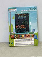 Front of packaging showing 10 inch LCD writing tablet with dinosaur party graphics.