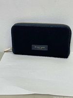 Black leather wallet with zipper and front brand plaque