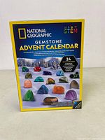 Front view of the unopened National Geographic Gemstone Advent Calendar box showing colorful gemstone images and branding.
