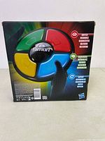 Back of Simon game box showing the colored buttons and multilingual instructions for playing and memorizing sequences