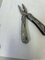 Multi tool fully opened showing needle nose pliers and wire cutter.