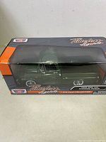 Front view of the Timeless Legends 1958 GMC 100 Wideside Pickup die cast model in its original box, showing green truck and clear plastic display window.