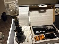 Absolut branded display in box with 4 D batteries and AC power adapter on table beside pub lamp