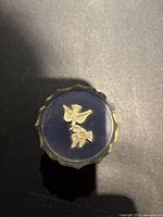 Top view showing two white bird motifs on blue ceramic surface with scalloped edge detail.