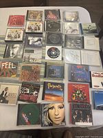 Photo showing a spread of over 20 CD jewel cases with albums from various genres including Broadway, rock, opera, and Christmas music.
