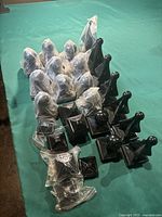 Photo of black metal fence post caps in three designs: spire tall caps, ball caps, and flat square caps arranged on table