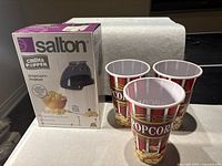 Salton Cinema Popper boxed popcorn maker and three popcorn containers