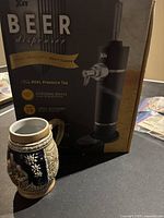 Photo showing the beer stein next to a box labeled 'Beer dispenser' indicating size and general shape of the stein.