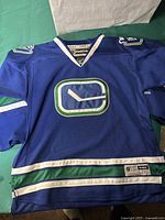 Front view of the blue Vancouver Canucks jersey with logo and trim details.