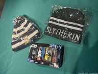 Lot contents showing Zak! Designs Star Wars mini glass set, Slytherin and Hogwarts toques all in packaging.