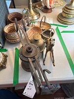 Photo showing iron mechanical item with handwoven baskets and brass bowls in background