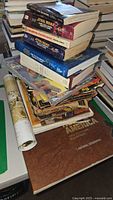 Stack of Star Wars novels, other books, and rolled poster partially unrolled on a table