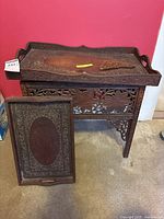 Full view of end table with carved tray and triangular accessory on top