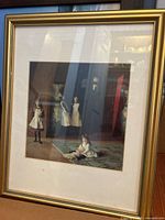Frontal photo of framed print showing four girls indoors, gold frame and cream mat seen