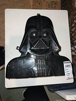 Front exterior of black Darth Vader–shaped plastic case