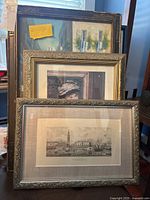 Three framed artworks stacked showing different frame styles and artwork.