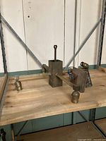 View of the brass chandelier frame with four light sockets arranged on a wooden surface, showing overall shape and construction.