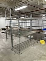 Two assembled Metro wire shelving units in a warehouse setting showing sturdy metal wire shelves and vertical poles.