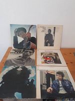 Photo showing all six Bob Dylan vinyl album covers arranged in two rows on a wooden surface.