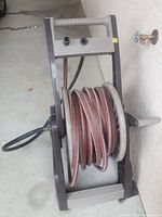 Top down view of the garden hose wound around the plastic reel with attached handle and hose connectors