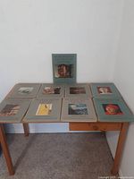 Nine vintage art books from the Metropolitan Seminars in Art series arranged on a wooden table, showing cover images and titles.