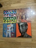 Photo of 4 Rolling Stones vinyl record covers front side, showing album artwork including Some Girls, Tattoo You, Goats Head Soup, and It's Only Rock 'n Roll.