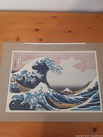 Front view of the print showing the wave and Mount Fuji, mounted on a board with wear at edges.