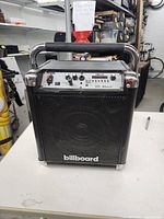 Front view of the Billboard Bluetooth speaker, showing grille, chrome handle, and control panel.