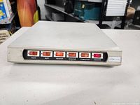 Front panel showing six labeled red rocker switches for controlling power: AUX2, AUX1, PRINTER, MONITOR, COMPUTER, MASTER.