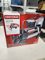 Front box view showing Craftsman inflator branding, airflow, voltage, and pressure specs.