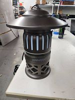 Front view of the Dynatrap mosquito and flytrap showing the top cover, light openings, and bottom vent cage.