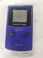 Front view of purple Nintendo Game Boy Color handheld console showing screen, buttons, and speaker with signs of wear.