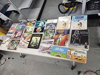 Overhead image of 18 Gary Larson Far Side books laid out on a table showing a variety of illustrated cartoon covers.