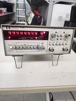 Front view of HP 5316B universal counter powered on showing red numeric LED display and front panel controls.