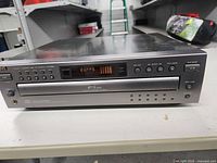 Front view of the JVC XL-F215 CD player showing digital display, disc tray, and control buttons.