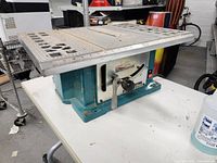 Side view of Makita table saw showing metal top, handle, and body.