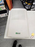 Top view of Mustek flatbed scanner with Mustek logo visible on lid, showing cream colored ribbed lid and overall unit shape.