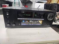 Front view of Onkyo TX-NR656 AV Receiver showing digital display and control knobs.