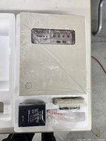 Alarm Center unit and accessories in original styrofoam packaging, plastic wrapped, showing overall contents