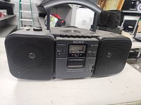 Front view of the Sony CFD-30 showing the central cassette deck with control buttons, digital display, and speakers.