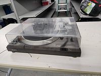 Sony direct drive automatic stereo turntable with transparent dust cover on, showing the front and side view.