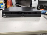 Front view of Toshiba HD DVD player showing power button, eject button, and HD DVD and DVD logos on front panel.