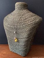 Vintage sterling silver necklace displayed on a woven bust showing the chain and citrine pendant.