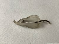 Front view of brooch on white background showing acrylic leaf and imitation diamond detail