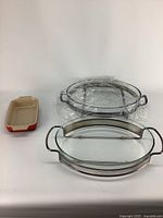 Three kitchen bakeware items shown together, including two glass Pyrex dishes and one ceramic Le Creuset baking dish