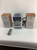 Full view of the Sony stereo system with two speakers and remote control on a white surface.