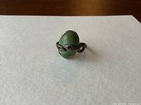 Front view showing serpent wrapping oval green stone