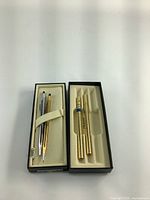 Two sets of vintage Cross pens and pencils, each in its box with cream suede-like inner lining.